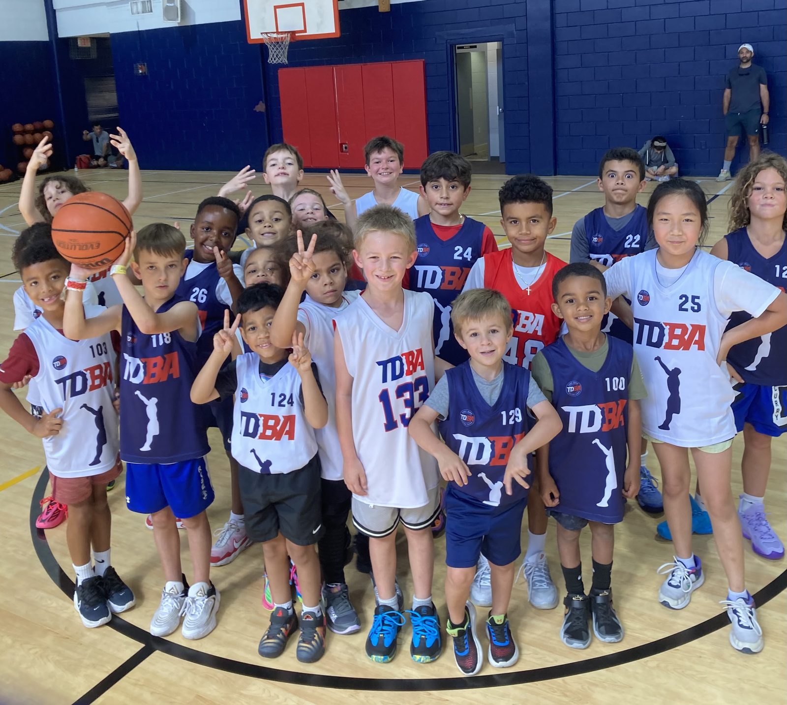A TDBA league team in numbered jerseys posing together at the Activities Building